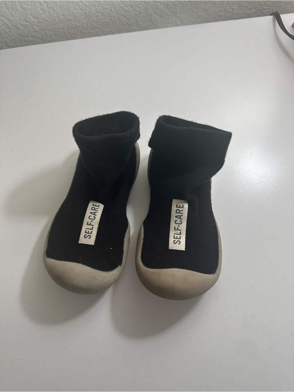 Kids Black Slip-On Knit Sneakers with 'SELF-CARE' Tag